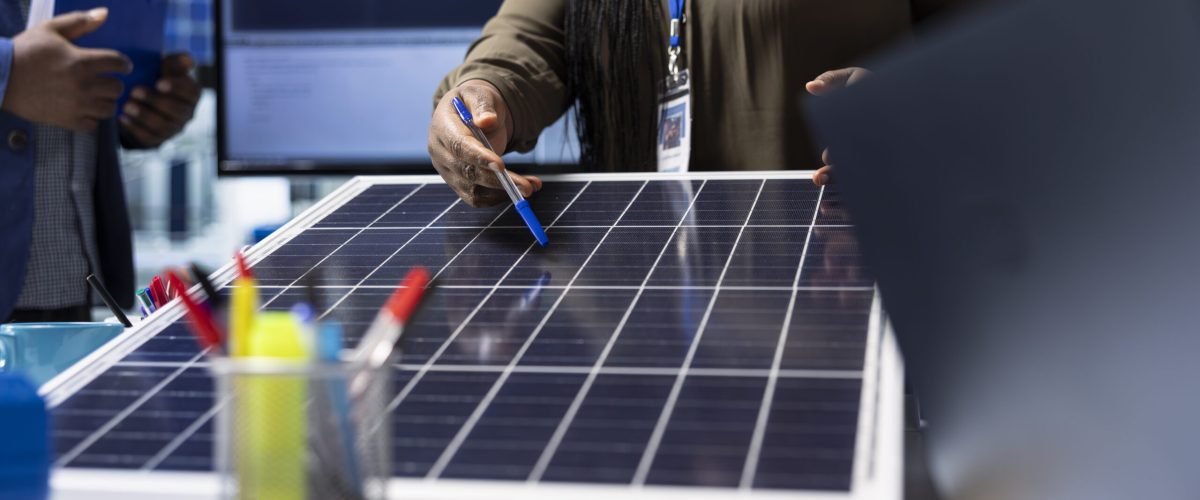 Shareholders meet with industrial plant manager to review solar panel components, analyzing material quality. Photovoltaics factory management executive presents solar panel features to investors